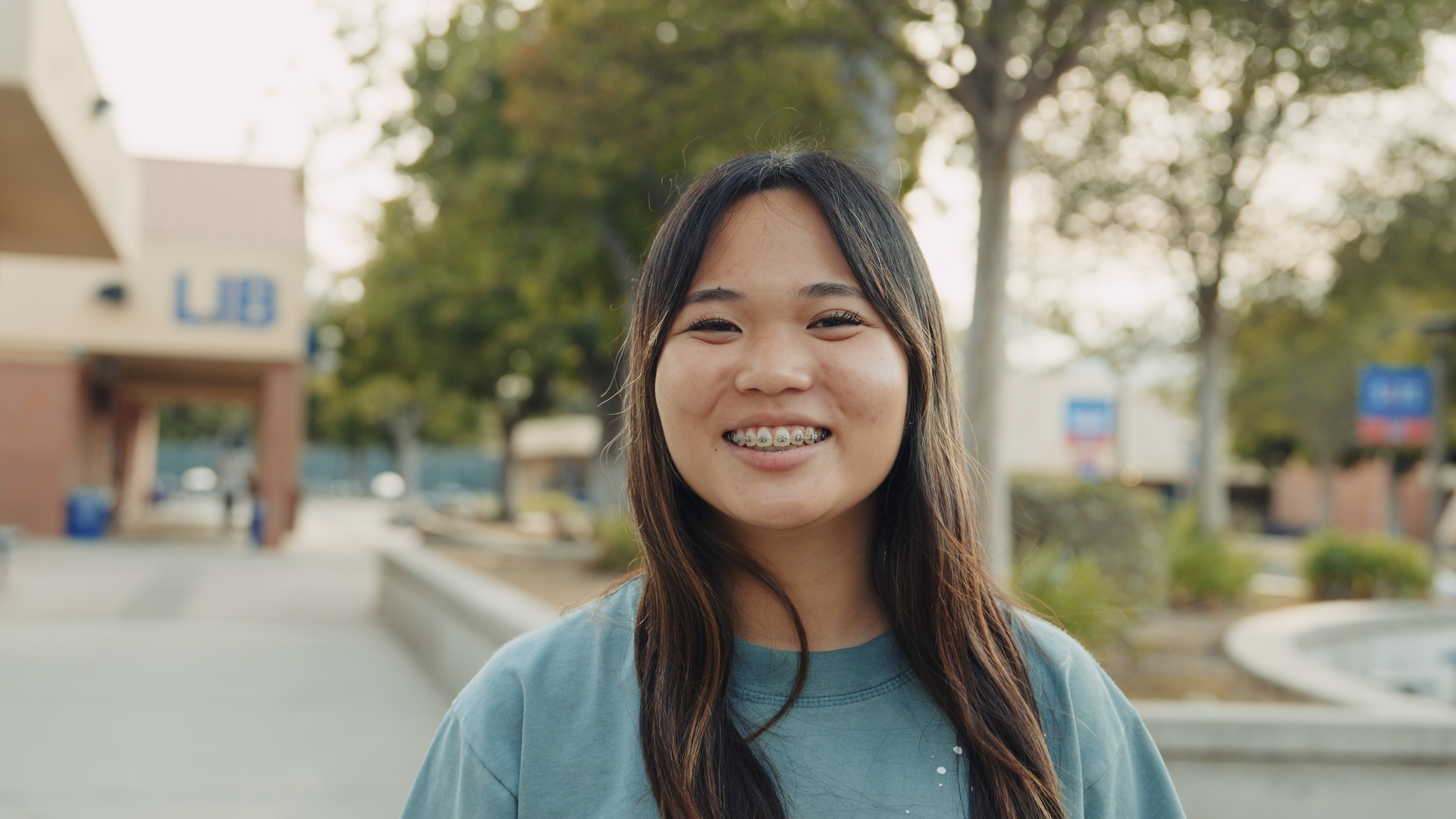 Leslie smiling outside her school